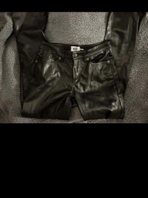 Svarta läderbyxor från 157 - Snygga svarta läderbyxor från 157 med fem fickor och raka ben. 