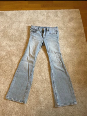 Ljusblå bootcut jeans i denim - Säljer ett par ljusblå bootcut jeans i klassisk denim med fem fickor och normal midja. Jeansen har en lätt tvättad look och vida ben nedtill. Perfekta för dig som gillar retrostil och vill ha ett par snygga jeans med avslappnad passform. Nästan aldrig använda 💞 finns även uppe på vinted 