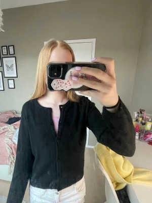 Svart kofta med knappar - En svart kofta med svarta knappar framtill och är i bomulls material.