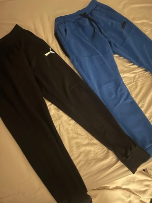 Puma och Nike mjukisbyxor - Båda byxorna för 60kr. Dragkedjan på dom blåa byxorna är trasig och de är ett litet hål på vänstra knät på dom svarta byxorna 