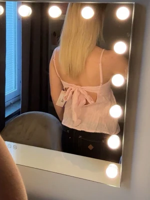 Ljusrosa linnetopp med rosett - Supersöt ljusrosa topp från Nelly, helt ny💕💕kom gärna med pris förslag!💕💕