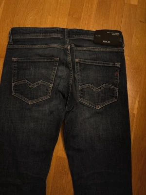 Mörkblå jeans från Replay - Snygga mörkblå jeans från Replay med klassisk femficksdesign och coola detaljer på bakfickorna. Jeansen har kontrastsömmar och en liten Replay-logga vid fickan. Perfekta för dig som gillar en tidlös och trendig look. Är öppen för förslag på priset 