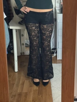 Svarta utsvängda spetsbyxor - Säljer ett par svarta utsvängda byxor i spets med inbygda shorts. Är endast testade och säljer pga för små. (Obs inte min bild)