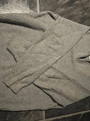 Två ribbstickade tröjor i grått och offwhite  - Säljer två ribbstickade tröjor, en i ljusgrått och en i offwhite. Båda har långa ärmar och rund halsringning. Perfekta att matcha med jeans, för en stilren look 100kr styck .
