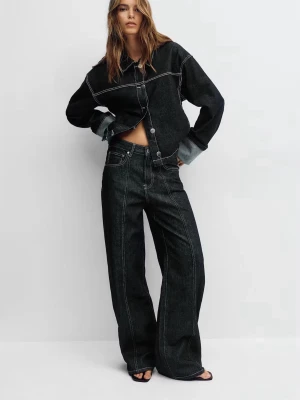 Svarta wide leg jeans med kontrastsömmar - Säljer ett par svarta wide leg jeans med högt liv och tydliga vita kontrastsömmar. Jeansen har klassisk femficksmodell och är tillverkade i kraftigt denimtyg. Perfekta för en trendig och avslappnad look.