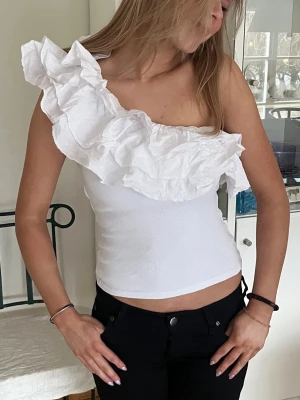 Populär vit volangblus oneshoulder från Zara  - Säljer denna topp från Zara som inte säljs längre. Storlek S och knappt använd då den inte passar mig🌸 Mycket bra skick!!