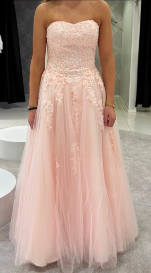 Balklänning - Jättefin rosa balklänning! Använd en gång men har tecken på användning längst ner på underkjolen men det syns inte då klänningen är på. Storlek 34 så passar xs-s, har en korsett i ryggen så passar lite olika storlekar.