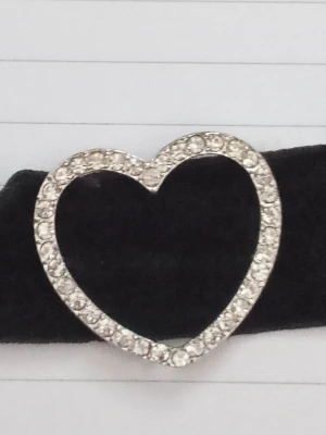 Choker hänge/dekoration - Säljer det här hjärtat med diamanter på som sitter på en choker. Självaste chokern är trasig så jag säljer bara hjärtat. Har använts en del.