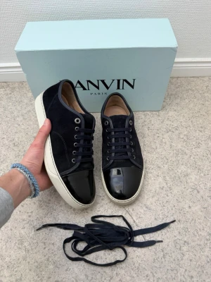 Lanvin - Säljer ett par marinblå lanvin dbb1 patent cap toe | storlek 7 eu41 men passar större | väldigt bra skick | finns ett litet hack på lackade delen annars väldigt bra | pris går att diskutera vid snabb affär | allt ingår vid köp