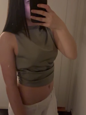 Grön festtopp med öppen rygg  - Snygg grön omlottopp med öppen rygg som knyts med en stor rosett. En perfekt festtopp! 