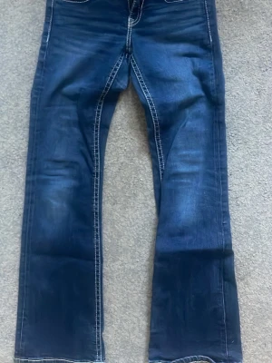 Fina mörkblå utsvängda lågmidjade jeans - Detta är ett par jättesnygga jeans i mörkblå färg som är utsvängda och lågmidjade går perfektion vilken topp som helst