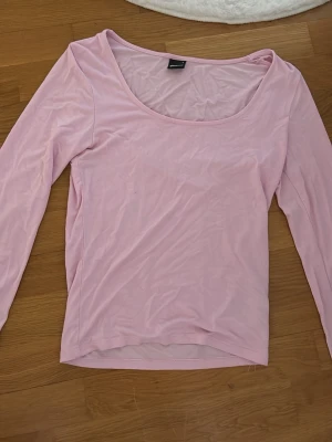 Ljusrosa långärmad topp Gina Tricot - Söt ljusrosa långärmad topp från Gina Tricot med rundad urringning. Tillverkad i mjukt och stretchigt material som sitter skönt på kroppen. Perfekt att styla med jeans eller kjol för en enkel och fräsch look.