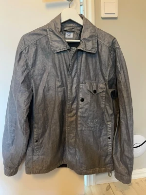 Grå overshirt från C.P. Company - Grå snygg cp company Overshirt. Jackan är helt ny köpt på NK i Stockholm för 5300kr på rea. Säljer billigt så det är först till kvarn. Jackan är i storlek M. Som sagt är overshirten helt ny inga tecken på användning alls. Kostar typ 6500kr ny idag. Pris kan diskuteras men endast vid snabbt köp!