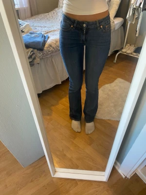 Mörkblå bootcut jeans - Snygga mörkblå bootcut jeans med klassisk femficksdesign och kontrastsömmar. Jeansen har medelhög midja och en liten logopatch bak i linningen. Perfekta för dig som gillar en tidlös och avslappnad stil.