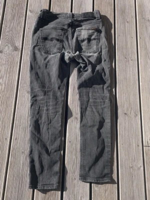 Grå jeans från Nudie Jeans - Säljer ett par grå/ Svarta nudie jeans i storlek W29 L32. De är i ett mycket bra sick och har inga defekter. Det är bara att höra av sig vid minsta fundering🙌