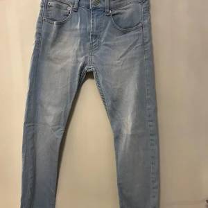 Ljusblå skinny jeans från Levi's - Säljer ett par ljusblå skinny jeans från Levi's med klassisk femficksdesign och knappgylf. Jeansen har en smal passform och är perfekta till vardags. Diskreta slitningar framtill för en avslappnad look.