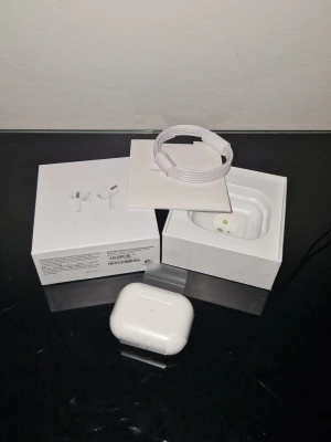 Apple AirPods Pro med laddningsetui - Säljer ett par vita Apple AirPods Pro med trådlöst laddningsetui. Kommer i originalförpackning med USB-C laddkabel och manual. Snygg och kompakt design i plast, perfekt för dig som vill ha grymt ljud och smidig anslutning till din iPhone eller andra Apple-enheter. PRIS DISKUTERAS