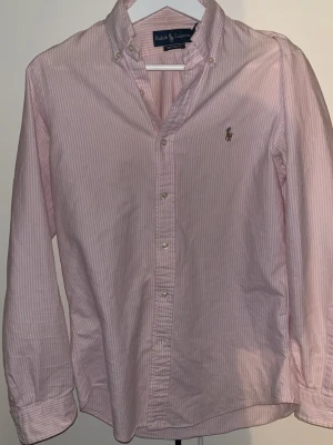 Rosa randig skjorta från Ralph Lauren - Ralph Lauren skjorta med Randig Rosa och vit färg. Storlek på denna är M men passar lika bra på S, Kan gå sänka priset vid en snabbaffär!