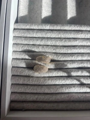 Guldiga statementringar med stenar - Två chunky ringar i guldton med massor av små glittrande stenar över hela ovansidan. Ringarna har en oval, välvd form och ger en riktigt lyxig känsla. Perfekta för dig som gillar att sticka ut med accessoarer.