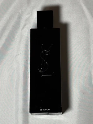 YSL Le Parfum svart flaska - Säljer en elegant parfym från Yves Saint Laurent, Le Parfum. Flaskan är helsvart men har ett jack i flaskan men det påverkar inget annnat, rektangulär och har YSL-loggan diskret präglad på framsidan. Modern och stilren design som känns lyxig och tidlös. Perfekt för dig som gillar exklusiva dofter.