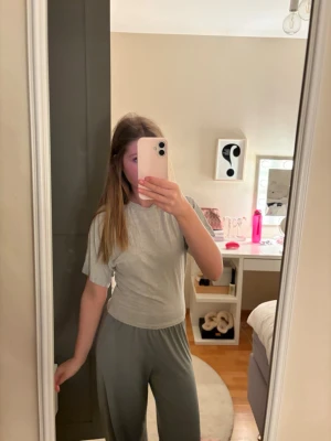 Ljusgrå kortärmad topp i bomull - En basic ljusgrå topp med korta ärmar och rund hals. Modellen är croppad och har en slim passform som sitter snyggt på kroppen. Tillverkad i mjuk bomull för en bekväm känsla. Den är tajtare vid midjan. Använt ca. 2 gånger. Priset kan diskuteras ❣️