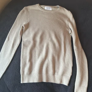 Beige tröja från Strömberg - Säljer en stilren beige tröja från Strömberg i ekologisk bomull och återvunnen polyester. Tröjan har en rund hals och långa ärmar med ribbade muddar. Perfekt för en avslappnad look.