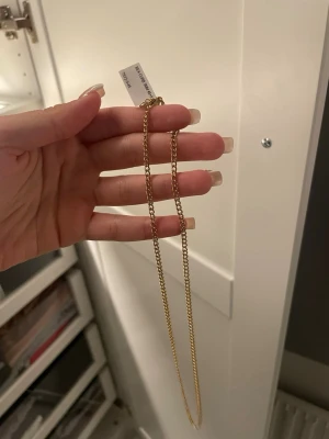 Klassiskt guldigt halsband - Snyggt och stilrent halsband i guldton med enkel kedja. Perfekt för dig som gillar minimalistiska smycken och vill ha något som funkar till många olika looks. Justerbar längd med liten kedjeförlängning och lås.