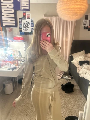 Beige velour loungewear-set - Mysigt beige loungewear-set i mjuk velour med dragkedja framtill och huva på tröjan. Byxorna har resår i midjan och raka ben. Perfekt för chill dagar hemma eller när du vill vara extra bekväm gamla ginatricot mjukis sett en del för 50 eller settet för 90, pris kan diskuteras .