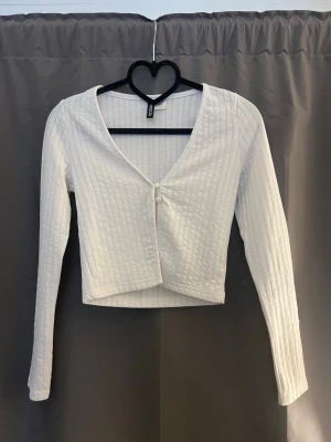 Vit croppad ribbad topp H&M - Säljer en vit croppad topp från H&M med lång ärm och ribbad struktur. Jätte fin med linne under!  Aldrig använd 🤍