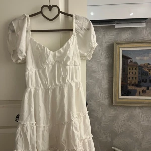 Vit kortklänning med puffärm - Vit supersöt klänning. Passar perfekt till studenten eller konfirmation. Endast använd 2 gånger. Varumärke: Dennis maglic 