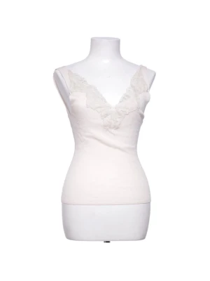 Vit spetsdetaljerad linnetopp Zara - Säljer en vit linnetopp från Zara med v-ringning och fina spetsdetaljer längs urringningen. Toppen är ärmlös och har en feminin, slim passform som sitter snyggt på kroppen. Perfekt att styla med jeans eller kjol för en trendig look.