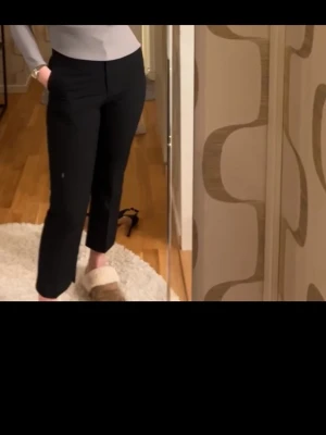 Svarta kostymbyxor med raka ben - Säljer ett par stilrena svarta kostymbyxor med raka ben och hög midja. Byxorna har diskreta fickor i sidorna och är perfekta för en clean och modern look. Materialet känns mjukt och följsamt, vilket gör dem bekväma att bära hela dagen.