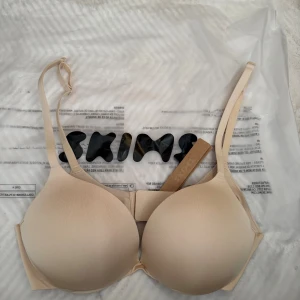Beige push-up bh från Skims - Motsvarar en 65C i eu storlek: Säljer en beige push-up bh från Skims med justerbara axelband och bygel. Bh:n har slät yta och klassisk hakknäppning bak. Perfekt för dig som vill ha en enkel och stilren bh under alla typer av plagg.