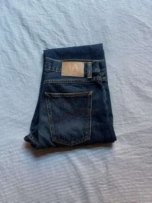 Nudie Jeans “Steady Eddie II” Blue Soil - Säljer ett par riktigt fina jeans från Nudie Jeans, modellen Steady Eddie II i färgen Blue Soil.  Köpte dem för runt 1600. Har bara använt dem 2–3 gånger, så de är i väldigt fint skick.  Riktigt bra kvalitet, 100% bomull, och de känns rejäla och håller länge. Storlek W30 L30.                Midja ca 40–41 cm.  Lår ca 28–29 cm. Benöppning ca 17–17.5 cm. 	Innerbenslängd ca 75–76 cm Ytterbenslängd  ca 105–106 cm. Jag på bilden är 180 cm.
