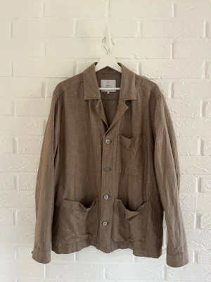 Overshirt från Bläck - Stilren overshirt från Bläck i ett lätt och luftigt material, perfekt för lager på lager. Klassisk krage, tre framfickor och knäppning med fyra knappar. Skandinavisk design som ger en avslappnad men snygg look.