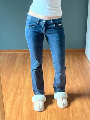 Blå bootcut jeans från Calvin Klein - Snygga blå bootcut jeans från Calvin Klein med dekorativ vit söm på bakfickan💕