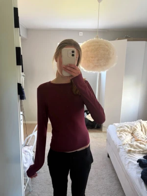Mörkröd långärmad topp - En enkel och stilren mörkröd långärmad topp med rund . Materialet känns mjukt och stretchigt.