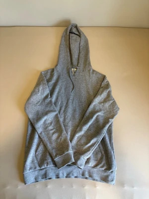 Grå hoodie från Pier One  - Grå Pier One hoodie i snygg och enkel stil. Väldigt bekväm och mjuk att ha på sig, passar perfekt till vardag eller chill outfits. Har huva med snören och stor ficka framtill. Bra skick utan större slitningar. Enkel att matcha med nästan allt.