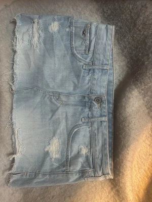 Hollister kjol med hål - Säljer min suuuper sugga jeans kjol från hollister med snygga detaljer i storlek S , inte använd mycket därav i mycket bra skick! ☺️