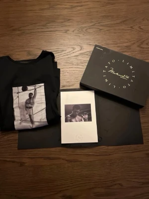 Limitato T-shirt - Säljer en svart t-shirt från Limitato med ett ikoniskt svartvitt foto av Muhammad Ali på bröstet. T-shirten har rund hals och korta ärmar. Kommer i exklusiv box med tillhörande kort. 