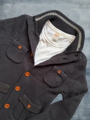*Unik* Stickad Cardigan med Knappar - En mycket trevlig stickad cardigan i en lite dovare marinblå färg, mest sanningsenlig på första bilden. Hör av dig vid frågor! 