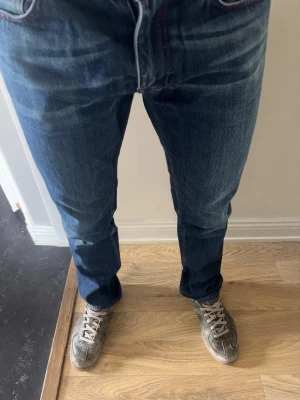Acne Studios Jeans - Snygga blå jeans från Acne Studios med snygg passform och klassisk femficksdesign. Jeansen har lätt slitna detaljer och kontrastsömmar. Tillverkade i mjuk denim med en autentisk tvättad look. Storlek 33/32- Vega Red Seam. Pris kan diskuteras!!