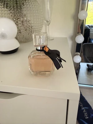 Yves Saint Laurent Mon Paris parfym - Säljer en lyxig parfym från Yves Saint Laurent, Mon Paris. Flaskan är genomskinlig med en ljusrosa vätska och har en elegant svart rosett med gulddetalj runt halsen. Klassisk och stilren design som passar perfekt på sminkbordet. Även andra parfymer som följer med, dessa köptes på en marknad är osäker om de skulle kunna vara en dope! Men har en god doft,sitter bra under dagen! Dessa är använda olika mycket men det finns mycket kvar, säljs därför till ett bra pris för dessa tre!