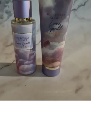 Victoria's Secret Love Spell Daydream - Victoria's Secret Love Spell Daydream set med body mist och lotion. Flaskan och tuben har ett drömlikt lila och rosa molnmotiv med gulddetaljer. Doften är fräsch och blommig, perfekt för dig som gillar söta och mjuka toner. Snygg design som sticker ut på hyllan. Helt nytt och oanvänt