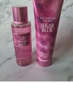 Victoria's Secret Sugar Blur set - Säljer ett set från Victoria's Secret Sugar Blur med en body mist och en body lotion. Båda har en söt doft av vaniljsocker, bärnsten och hallon. Förpackningarna är rosa med metallisk finish och bärmotiv. Perfekt för dig som gillar fräscha och söta dofter. Bodymisten är endast provsprayad men lotion är helt ny och oöppnad