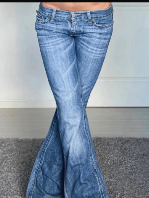 Blå bootcut jeans från Hollister! - Midjemått: 37cm och innerbenslängden:77cm