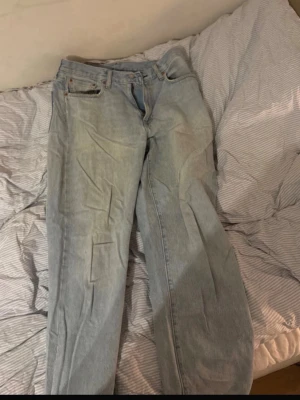 Ljusblå raka jeans från Levi's - Säljer ett par klassiska ljusblå jeans från Levi's med rak passform. Jeansen är tillverkade i slitstark denim. Perfekta för en avslappnad och trendig look.