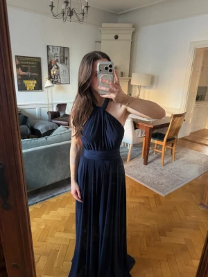 Marinblå balklänning från Bubbleroom - Söt långklänning från Bubbleroom som kan knytas på massvis med olika sätt! Visar bara några av sätten på bilderna! Perfekt till bal eller annat firande! Uppklippt ca 5cm då sen var för lång för mig som är 160, den är fortfarande lite lång så passar någon som är i den längden!💙 