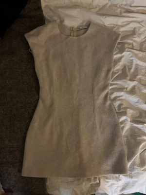 Beige figurnära klänning från Zara - Snygg beige miniklänning från zara med figurnära passform. Tillverkad i ett mjukt, stickat material som ger en stilren och modern look.💞❣️❤️ Mer en S än M