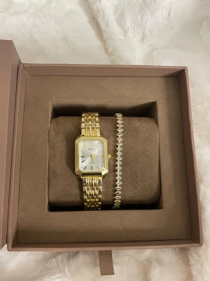 Jättefin guld klocka & armband  - Armbandet och klockan är helt nya och har plasten kvar samt är klockan plomberad fortfarande. 🤎  Klockan har ett helt nytt batteri och går att justera storleken enkelt hemma med en nål. 🪡   Perfekt som present eller till dig själv!🎁  OBS: boxen medföljer ej och klockan är inte från mockbergs 